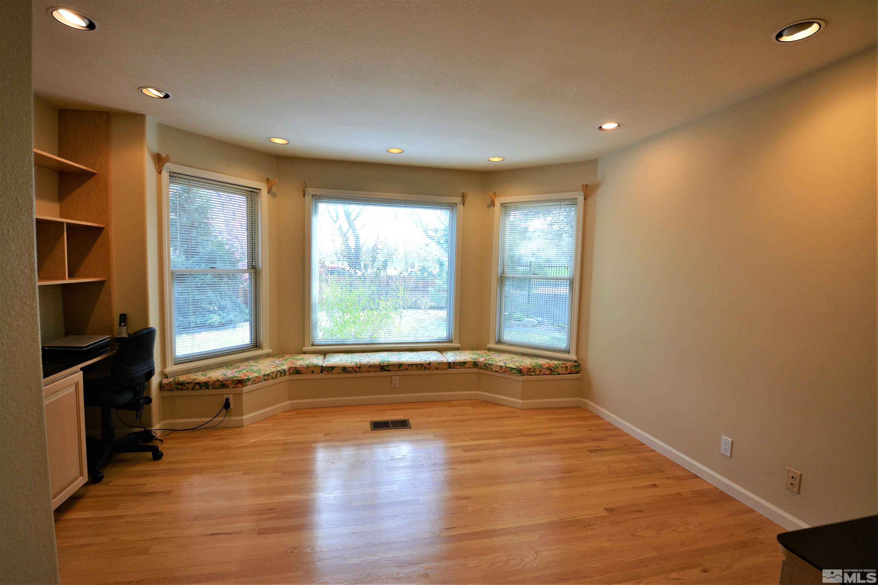 545 Skyline Boulevard Reno, NV 89509 - Photo 13 of 39 an empty room with wooden floor and windows