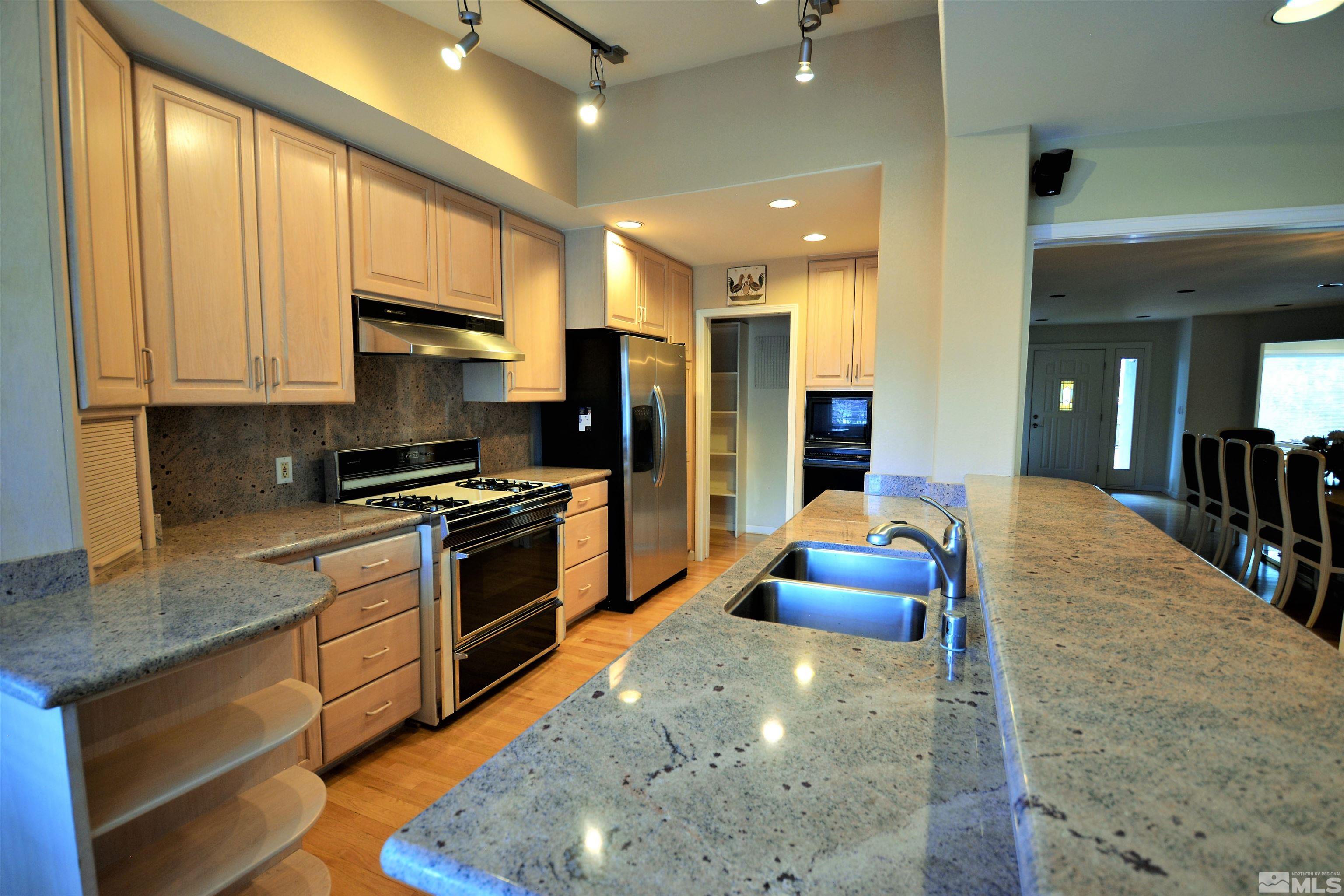 545 Skyline Boulevard Reno, NV 89509 - Photo 8 of 39 a kitchen with stainless steel appliances granite countertop a stove sink and cabinets