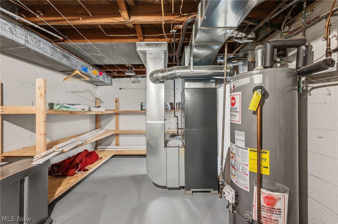 7750 Lewis Road Olmsted Falls, OH 44138 - Photo 40 of 50 Utility room featuring a water heater and furnace, exposed ceiling joists, and concrete block walls
