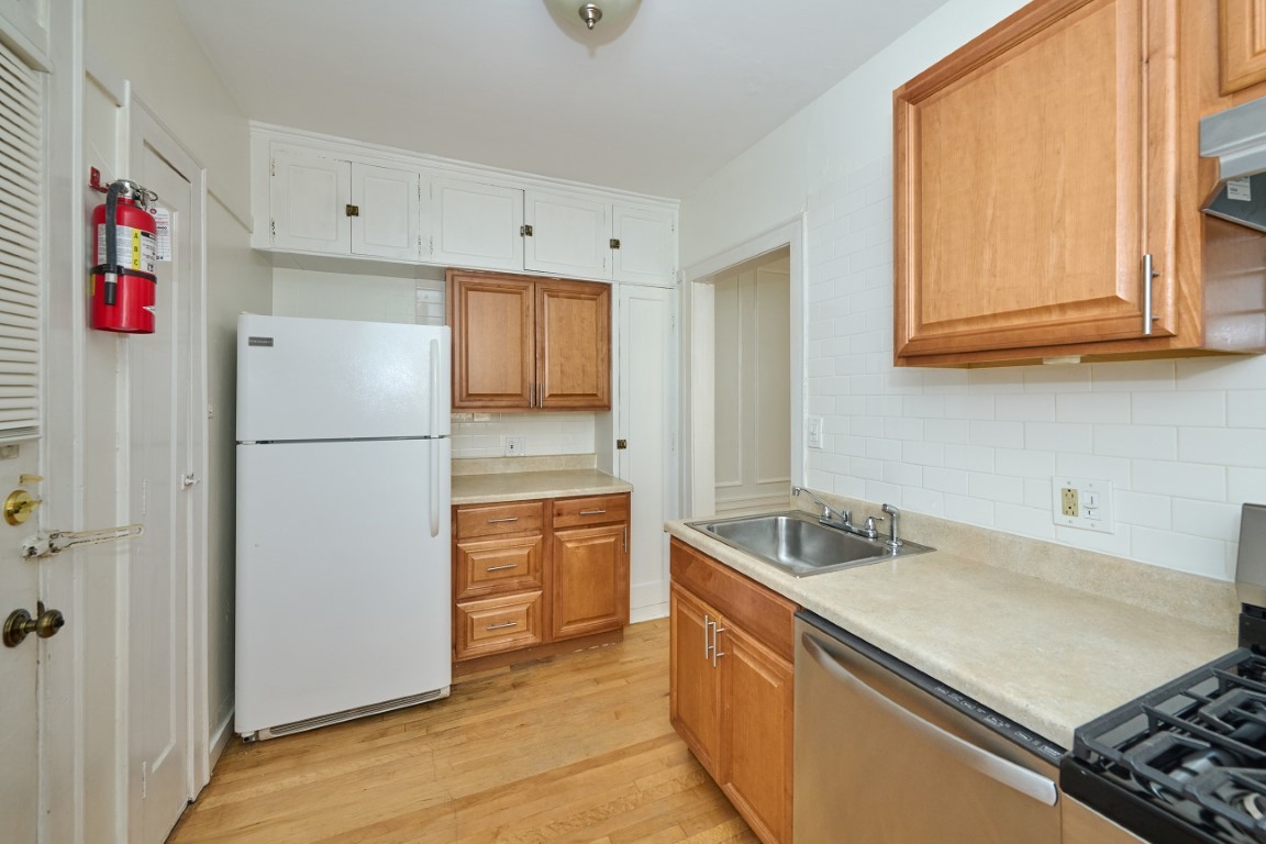 1112 Grove Street, Unit 2B Evanston, IL 60201 - Photo 13 of 21 a kitchen with stainless steel appliances granite countertop a refrigerator and a sink