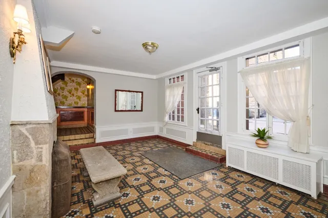 a living room with a bed furniture and next to a window