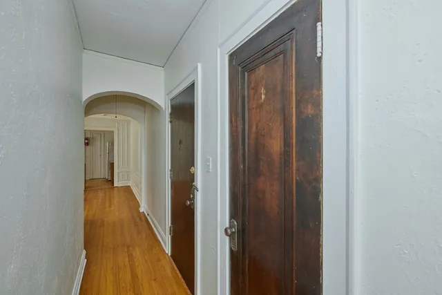 a view of a hallway with wooden floor
