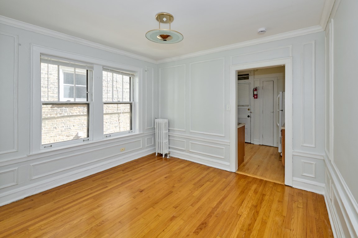 1112 Grove Street, Unit 2B Evanston, IL 60201 - Photo 10 of 21 a view of an empty room with wooden floor and a window