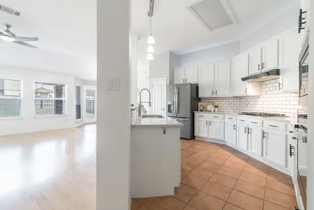 a kitchen with stainless steel appliances a refrigerator sink and cabinets