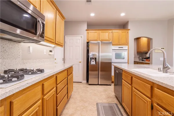 a kitchen with stainless steel appliances granite countertop a sink stove and refrigerator