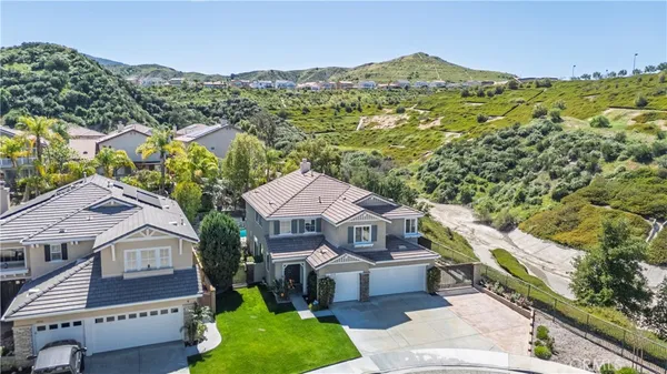 an aerial view of a house with a yard and green space