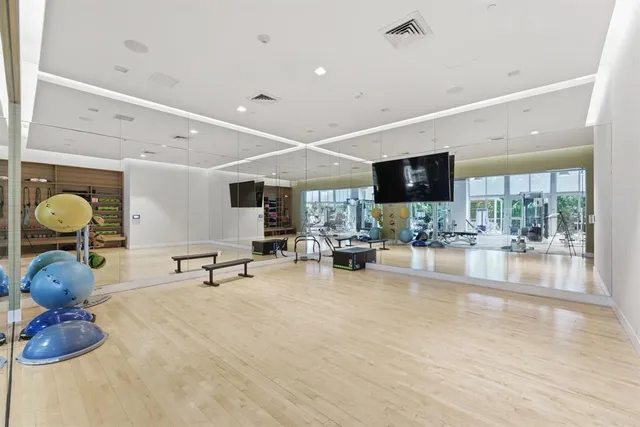 a view of a brick house with potted plants and a car parked in front of it
