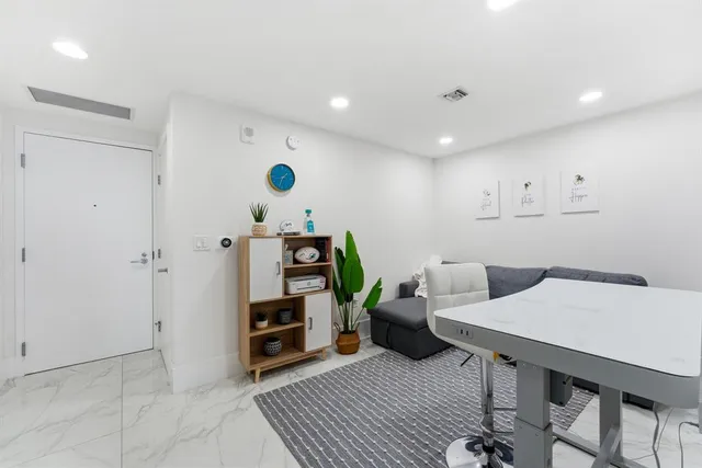 a kitchen with a dining table chairs and refrigerator