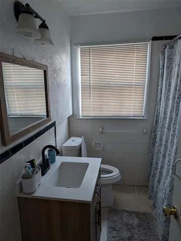 a bathroom with a sink toilet and a mirror