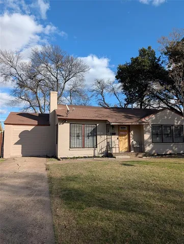 a front view of house with yard and trees in the background