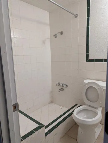 a bathroom with a granite countertop toilet and a sink
