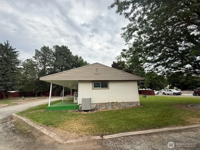a white house with a big yard and large trees