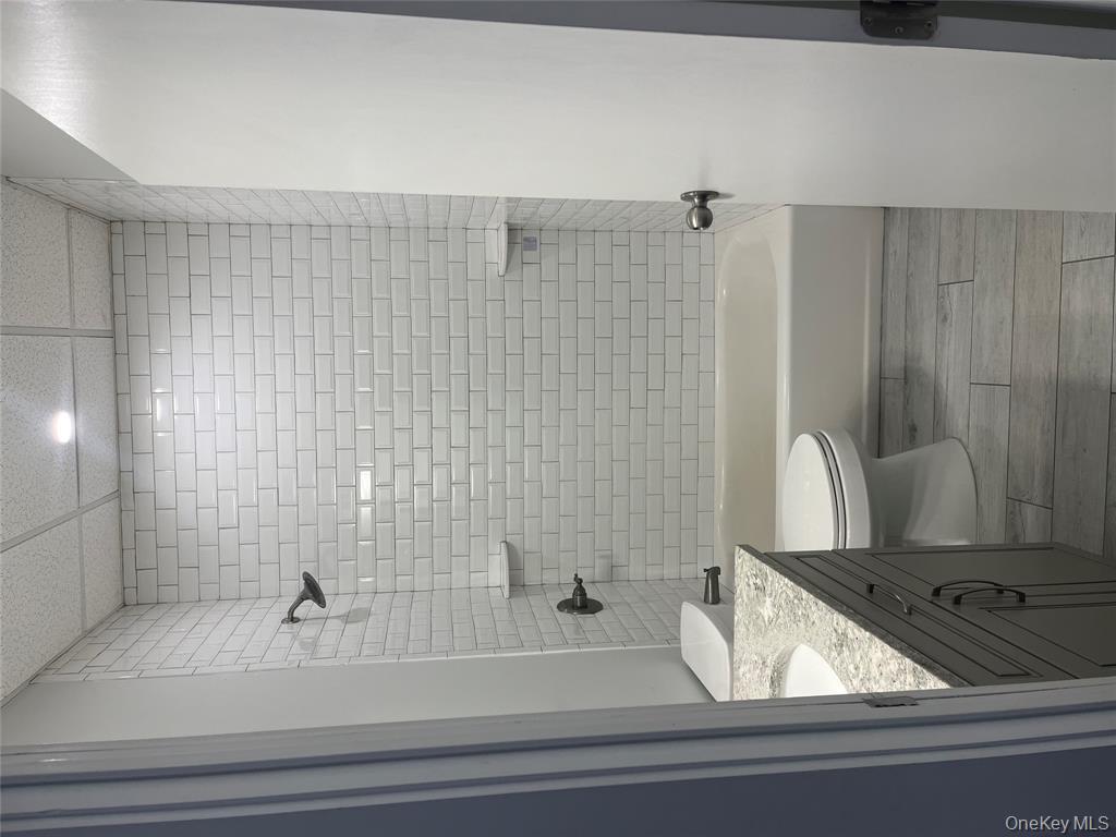 262 East Main Street, Unit D Babylon, NY 11702 - Photo 14 of 17 a bathroom with a granite countertop bathtub shower sink and toilet