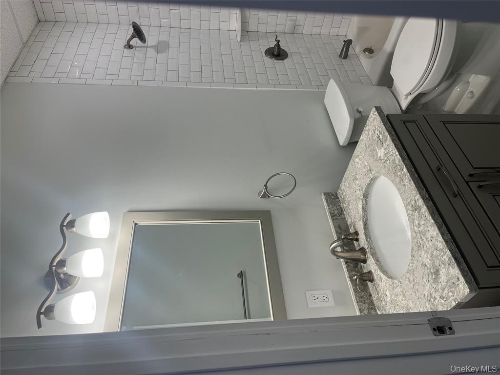 262 East Main Street, Unit D Babylon, NY 11702 - Photo 15 of 17 a bathroom with a granite countertop sink vanity mirror and toilet