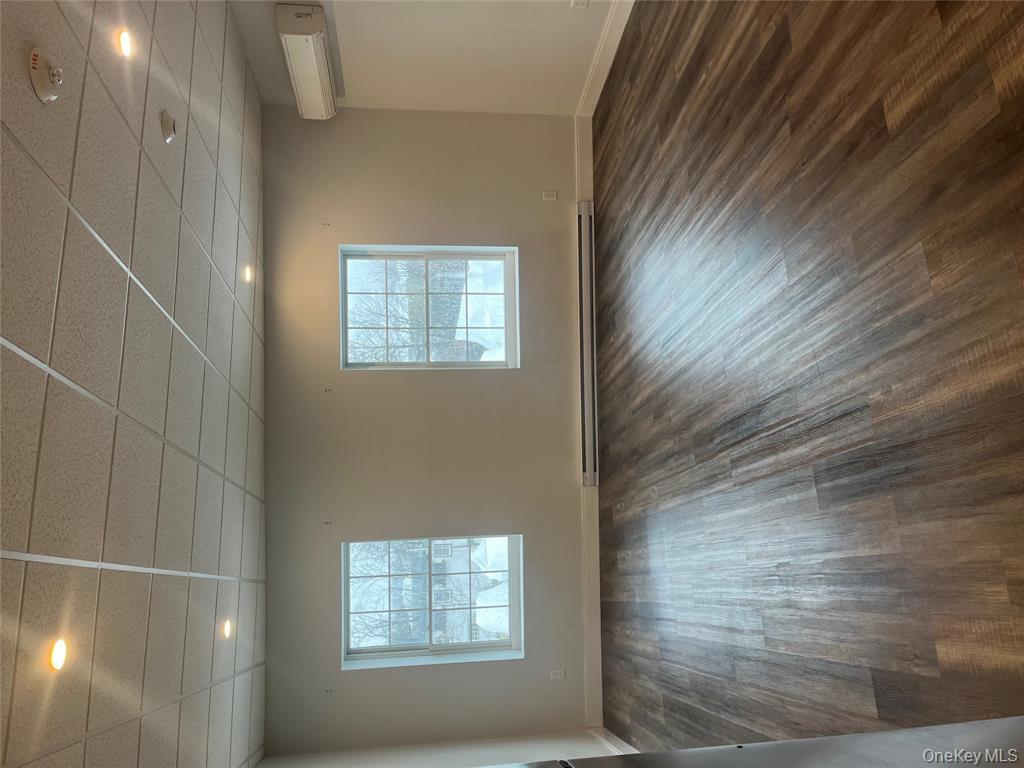 262 East Main Street, Unit D Babylon, NY 11702 - Photo 17 of 17 an empty room with wooden floor and windows
