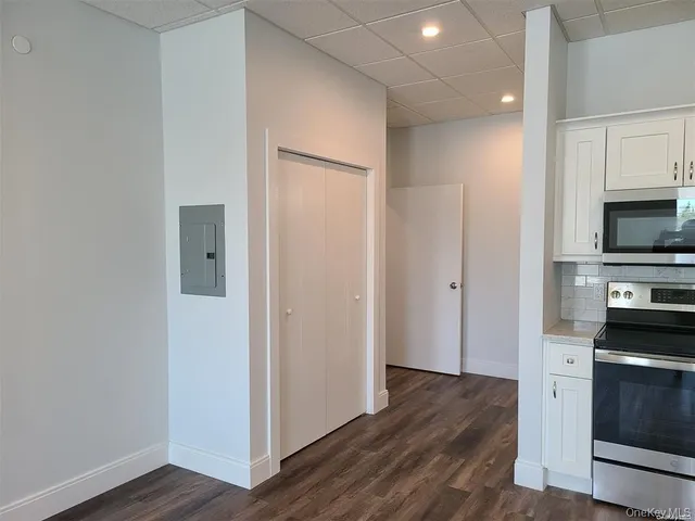 a view of a kitchen with wooden floor and electronic appliances