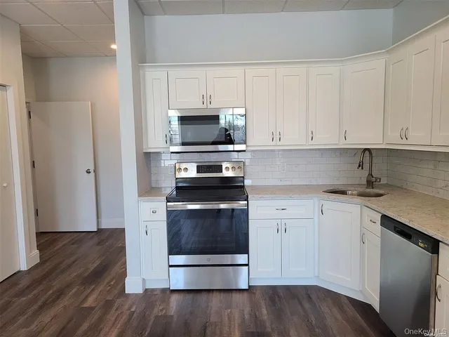 a kitchen with white cabinets stainless steel appliances and sink