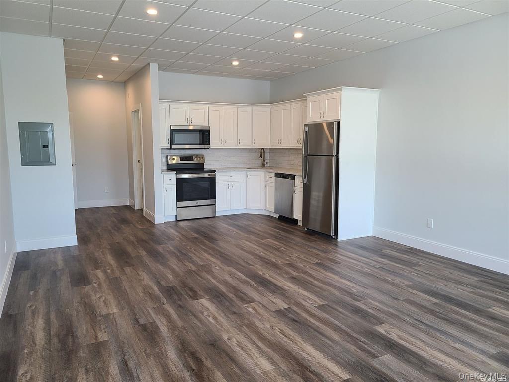 262 East Main Street, Unit D Babylon, NY 11702 - Photo 8 of 17 a kitchen with stainless steel appliances a refrigerator and a stove top oven