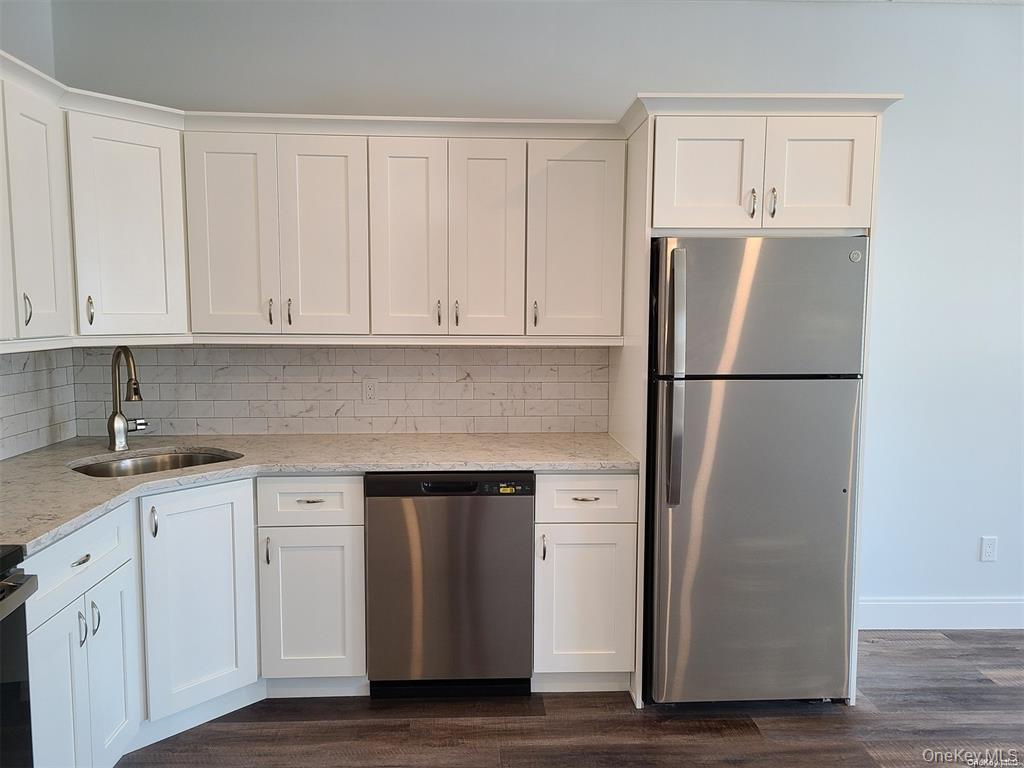 262 East Main Street, Unit D Babylon, NY 11702 - Photo 9 of 17 a kitchen with cabinets and stainless steel appliances