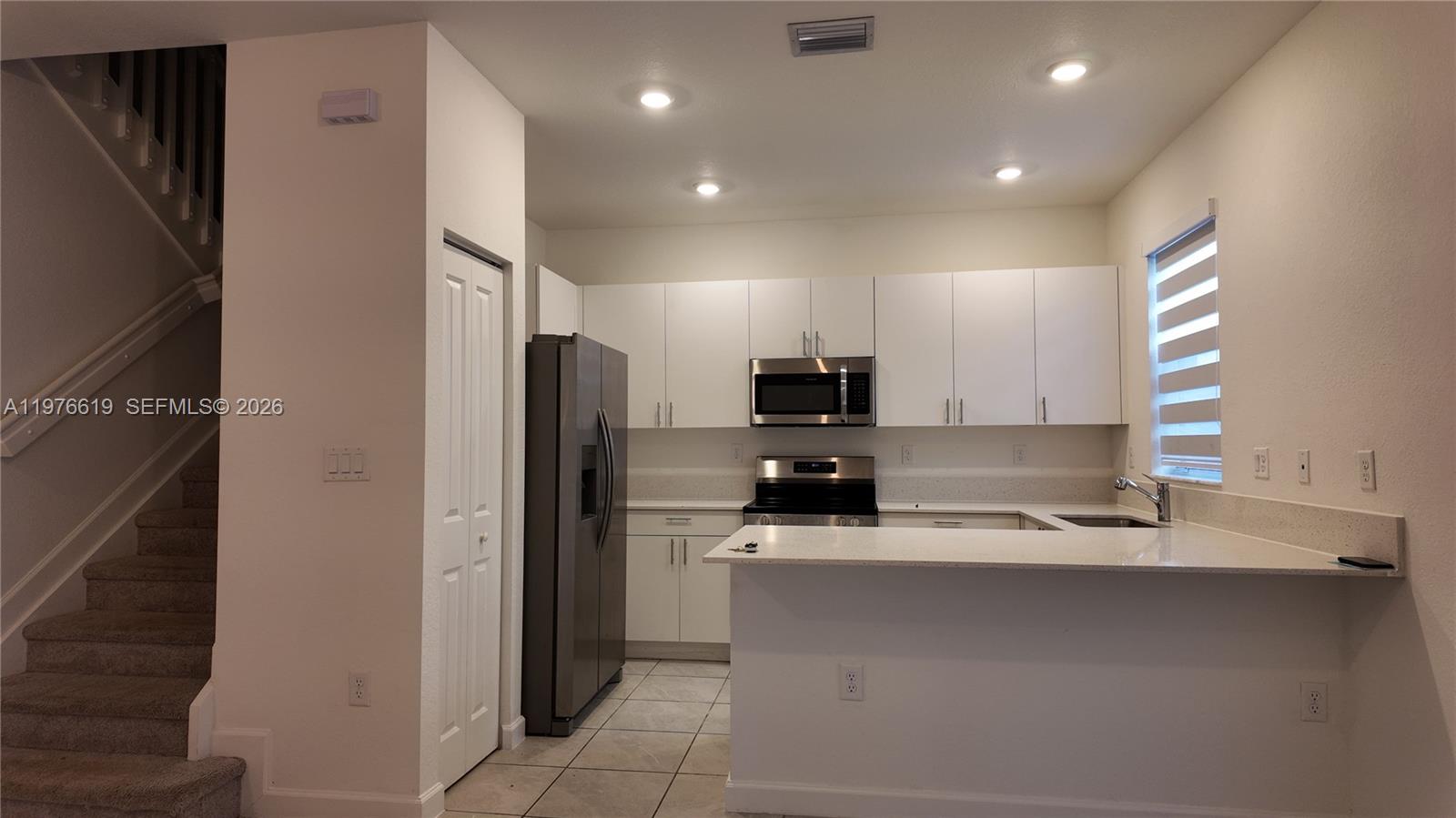 16243 Southwest 292nd Street, Unit 16243 Homestead, FL 33033 - Photo 13 of 30 a kitchen with stainless steel appliances a refrigerator sink and microwave
