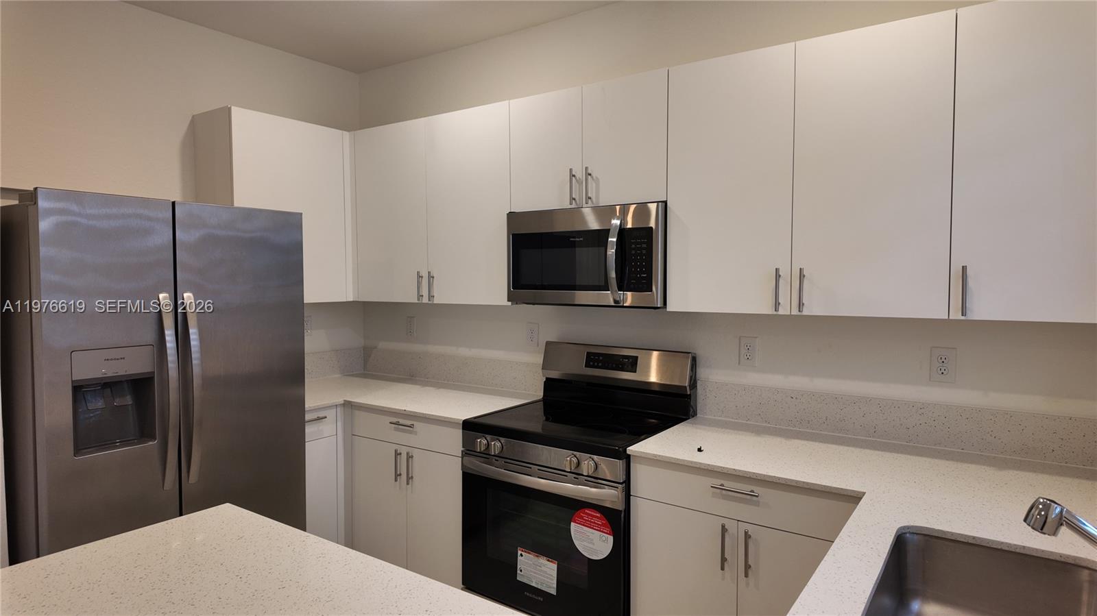 16243 Southwest 292nd Street, Unit 16243 Homestead, FL 33033 - Photo 14 of 30 a kitchen with a refrigerator sink and microwave