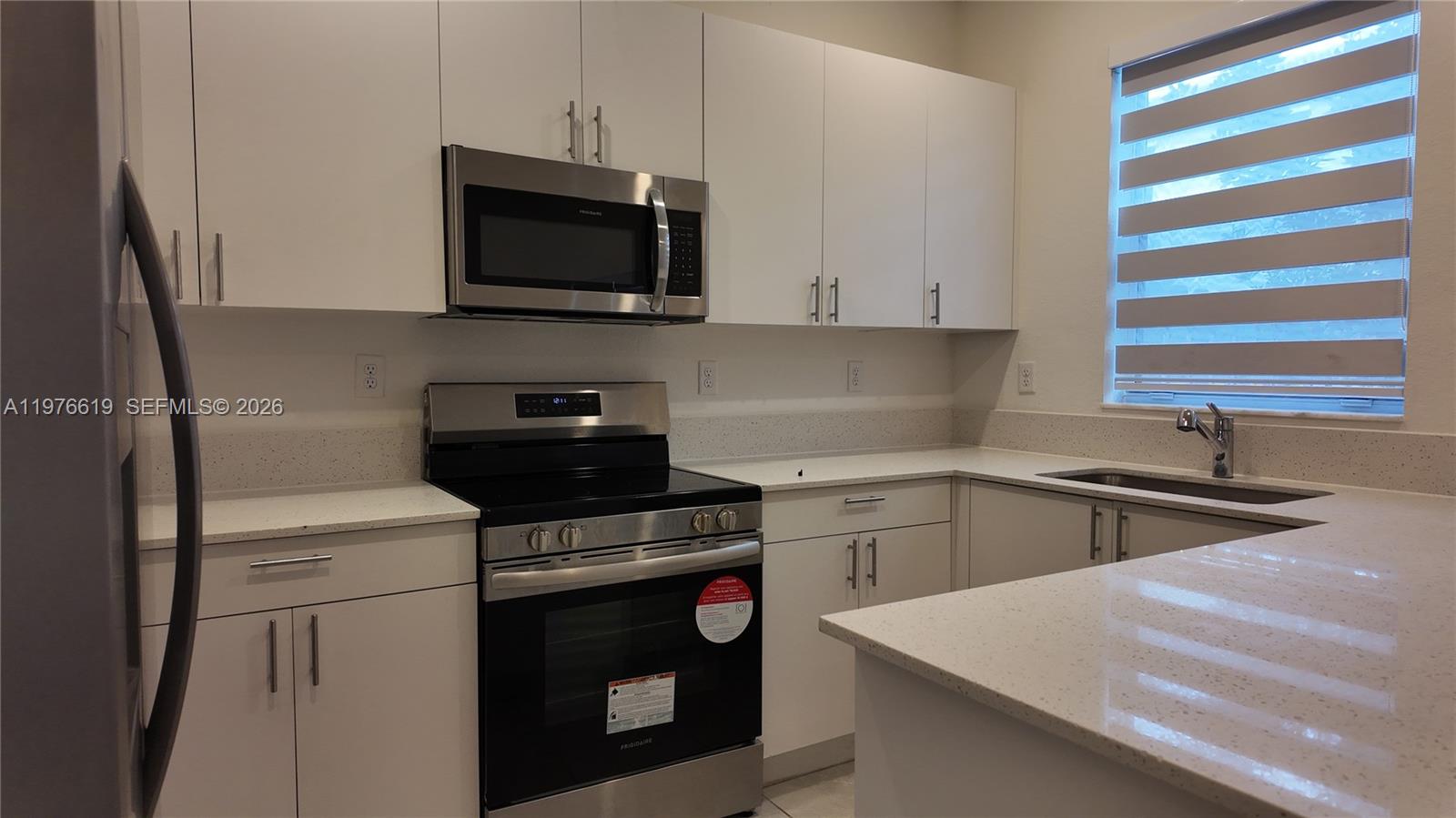 16243 Southwest 292nd Street, Unit 16243 Homestead, FL 33033 - Photo 15 of 30 a kitchen with a stove and a microwave