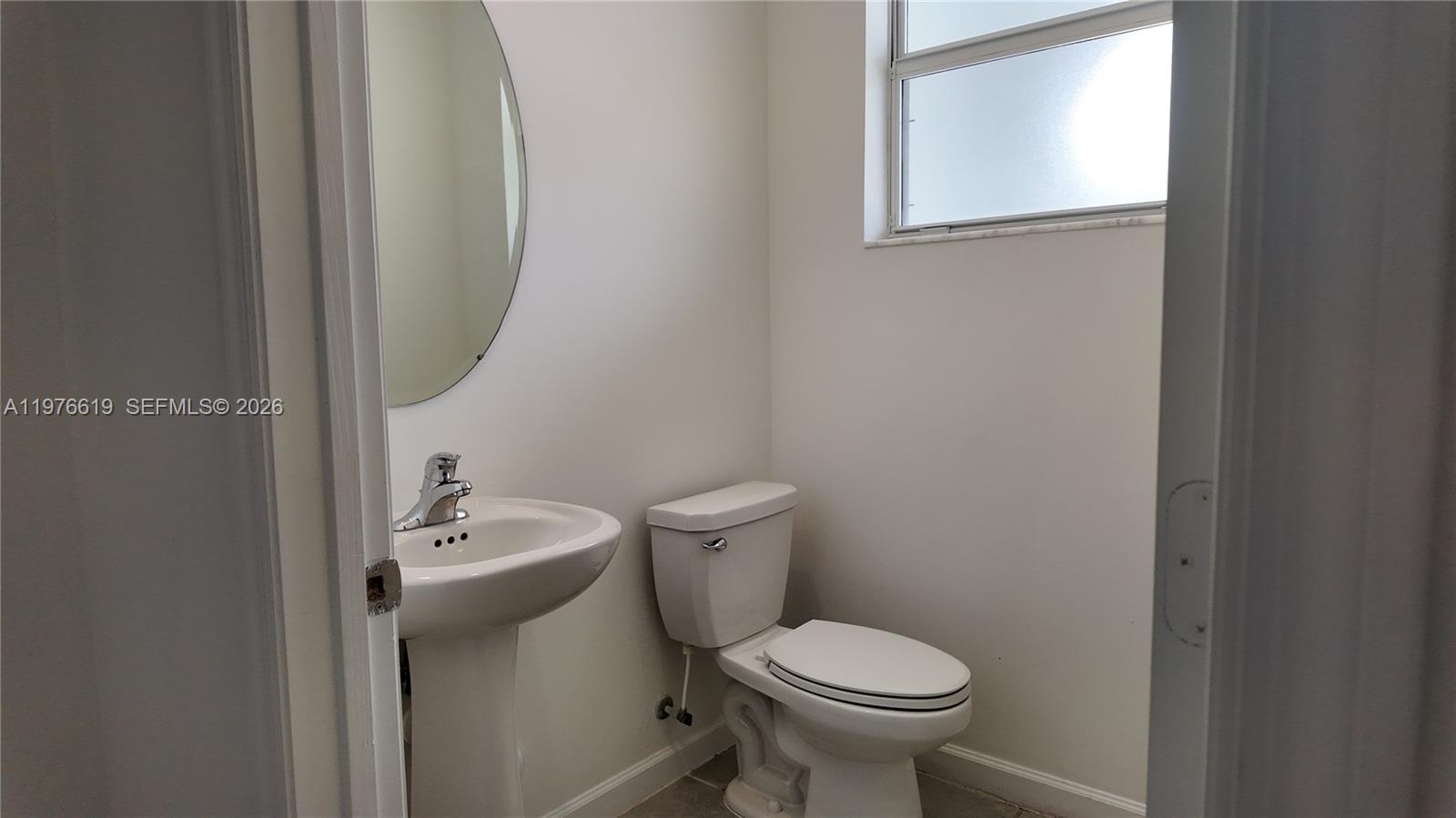 16243 Southwest 292nd Street, Unit 16243 Homestead, FL 33033 - Photo 16 of 30 a white toilet sitting next to a bathroom sink