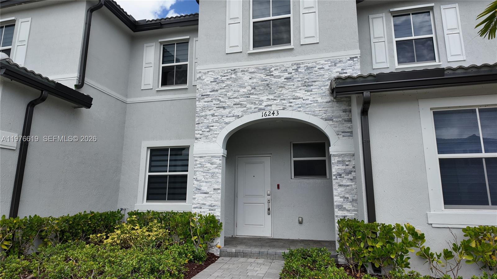 16243 Southwest 292nd Street, Unit 16243 Homestead, FL 33033 - Photo 2 of 30 a front view of a house with plants