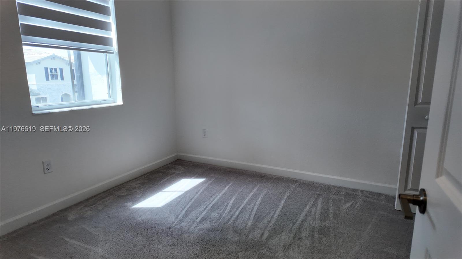 16243 Southwest 292nd Street, Unit 16243 Homestead, FL 33033 - Photo 25 of 30 a view of an empty room with a window