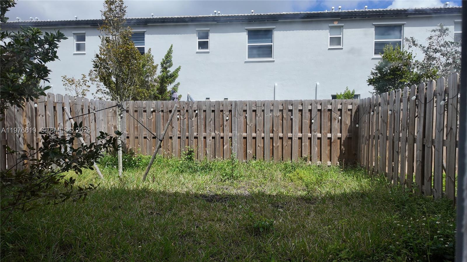 16243 Southwest 292nd Street, Unit 16243 Homestead, FL 33033 - Photo 29 of 30 a view of a backyard with potted plants and wooden fence