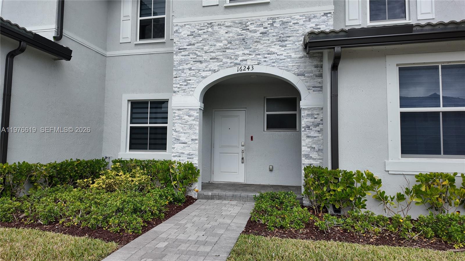 16243 Southwest 292nd Street, Unit 16243 Homestead, FL 33033 - Photo 4 of 30 a front view of a house with a garden