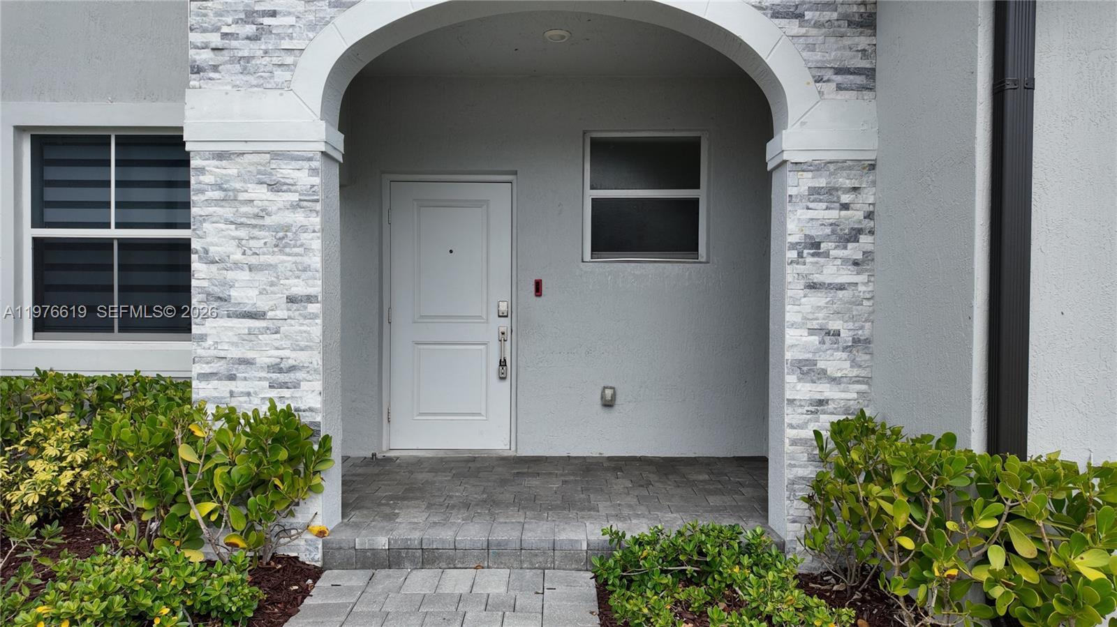 16243 Southwest 292nd Street, Unit 16243 Homestead, FL 33033 - Photo 5 of 30 a front view of a house with plants