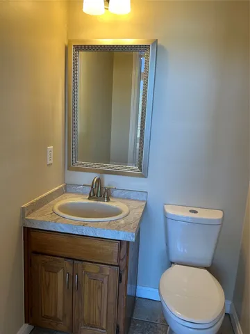 a bathroom with a toilet a sink and mirror