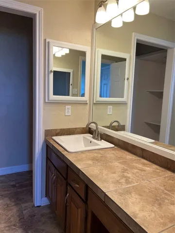 a bathroom with a granite countertop sink and a mirror