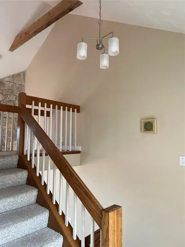 a view of staircase with railing and white walls