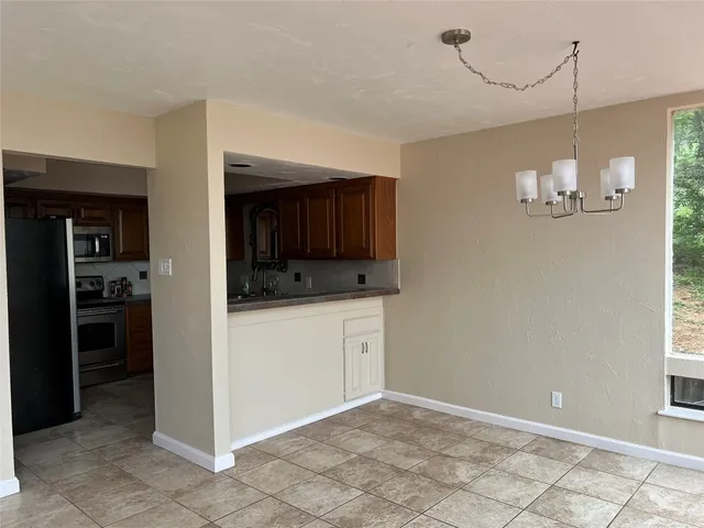 a view of an empty room with a kitchen