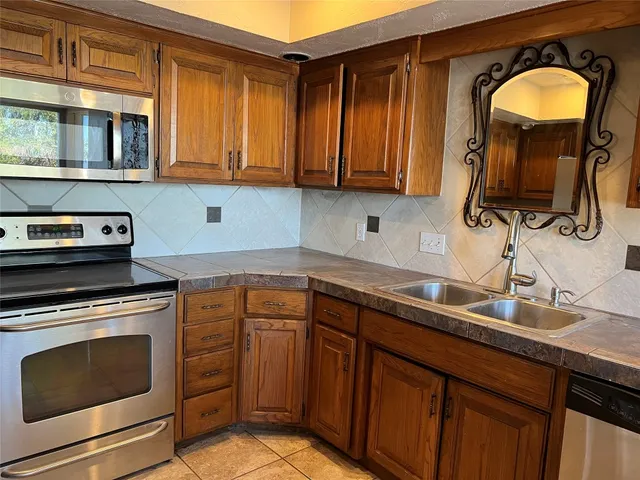 a kitchen with stainless steel appliances granite countertop a sink dishwasher stove and cabinets