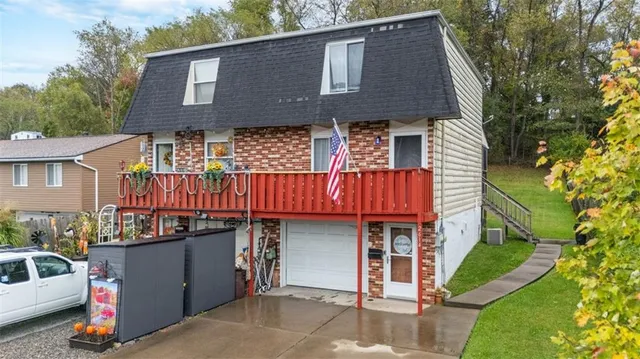 a view of a house with wooden deck and furniture