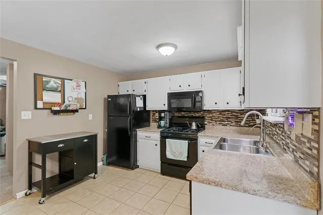 a kitchen with stainless steel appliances granite countertop a refrigerator sink and stove
