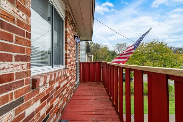 a view of a balcony with wooden floor and fence