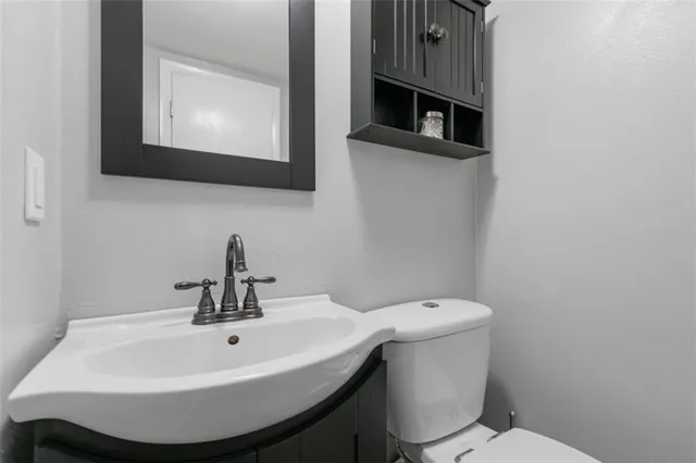 a bathroom with a toilet sink and mirror