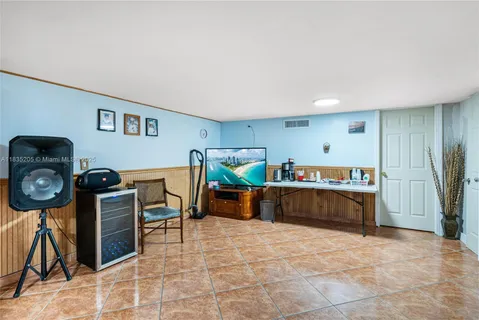 a living room with furniture and a baby crib