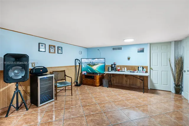 a living room with furniture and a baby crib