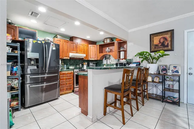 a kitchen with stainless steel appliances a refrigerator and a wooden cabinets
