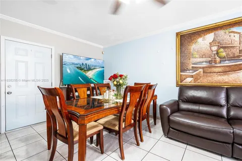 a dining room with furniture a large window and a rug