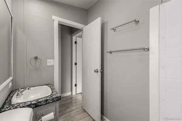 a bathroom with a granite countertop sink mirror vanity and toilet