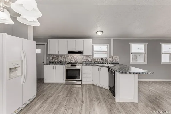 a kitchen with granite countertop white cabinets and white appliances