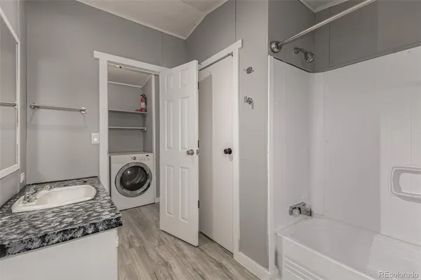 a bathroom with a granite countertop sink a mirror and a bathtub