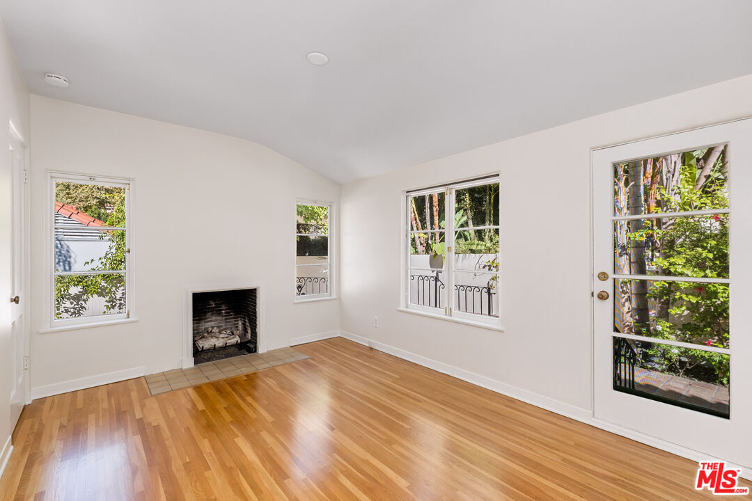 2120 Outpost Drive Los Angeles, CA 90068 - Photo 16 of 37 a bedroom with furniture a fireplace and wooden floor