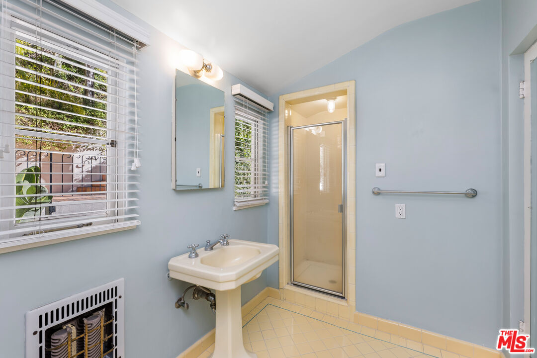 2120 Outpost Drive Los Angeles, CA 90068 - Photo 19 of 37 a bathroom with a sink a mirror and a shower
